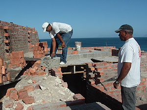 Stepping up Our builder (right) supervises work on what is the ground floor near a bathroom.